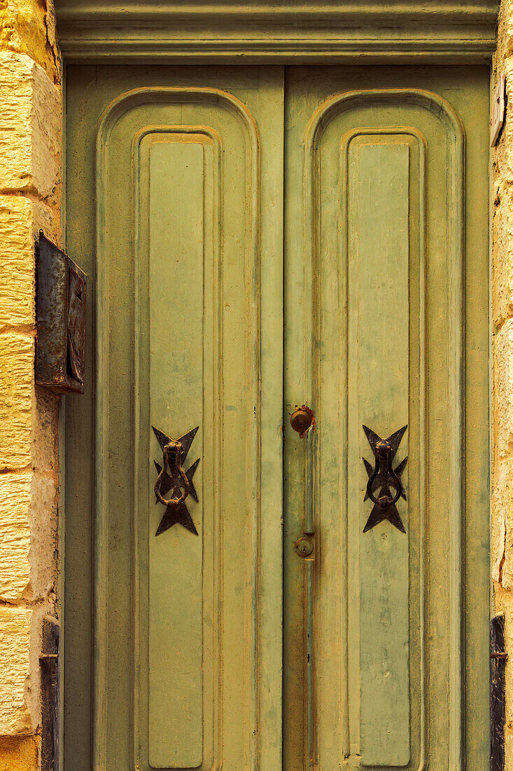 Traditional brass door knockers with Maltese cross design outside a building in the alleys of the old city of Birgu (Citta Vittoriosa), Malta, Mediterranean, Europe\n