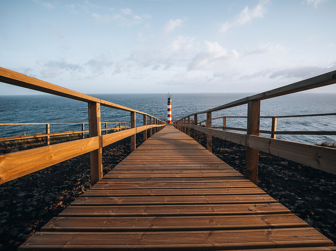 Farolim dos Fenais da Ajuda lighthouse with a symmetrical wooden path leading to it, Sao Miguel island, Azores Islands, Portugal, Atlantic, Europe\n