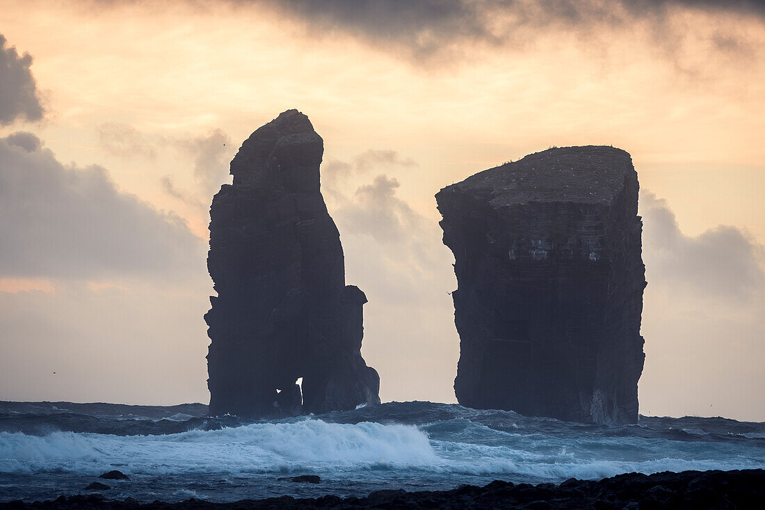 The sea stacks of Mosteiros at sunset with high waves in the foreground, Sao Miguel Island, Azores Islands, Portugal, Atlantic, Europe\n