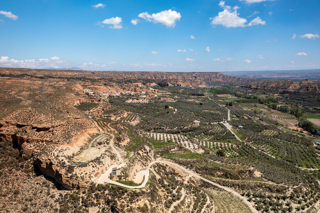 Drohnen-Luftaufnahme einer Straße durch eine wüstenartige Landschaft am Francisco Abellan-Staudamm, Granada, Andalusien, Spanien, Europa