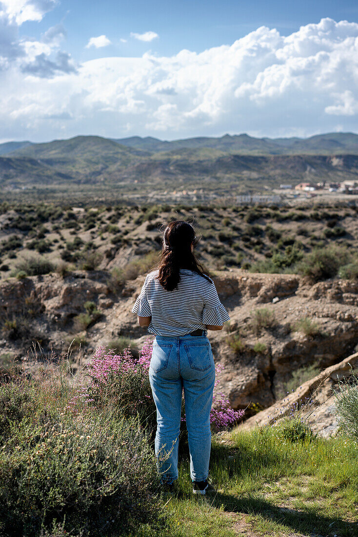 Young woman looking at Tabernas desert on a sunny day, Almeria, Andalusia, Spain, Europe\n