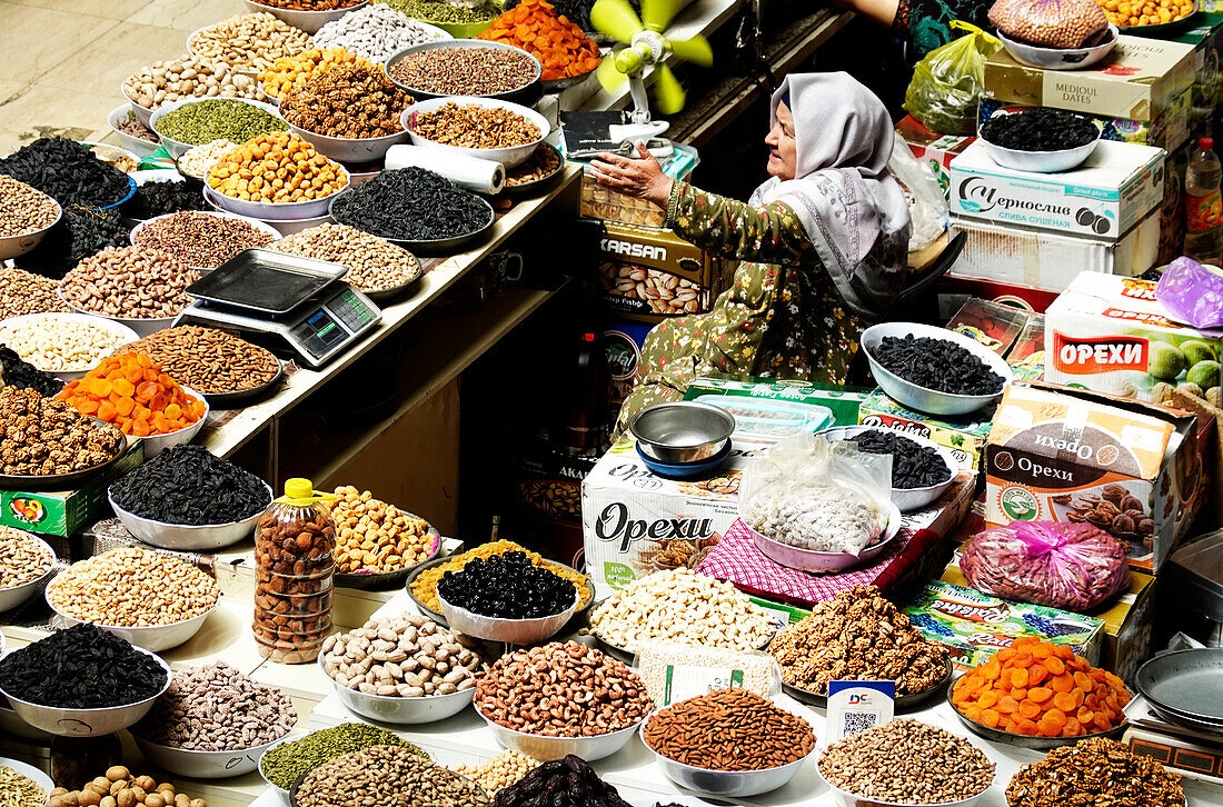 Frau verkauft Nüsse und Trockenfrüchte an einem Stand auf dem Zentralmarkt, Duschanbe, Tadschikistan, Zentralasien, Asien