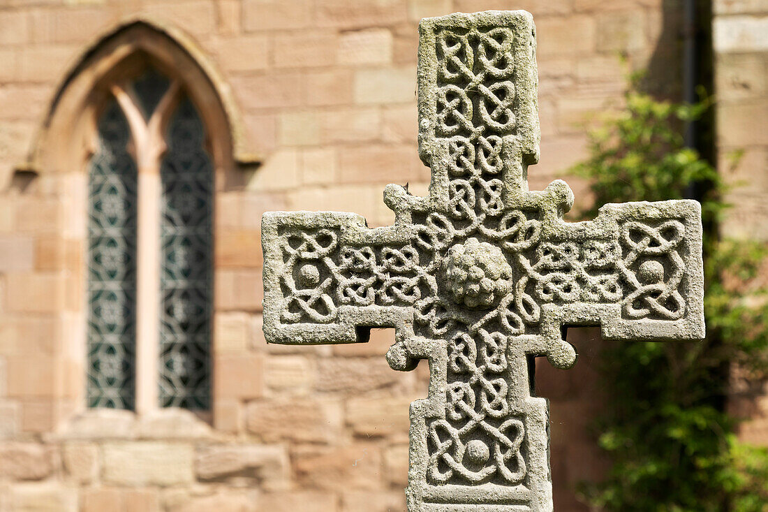 Anglo-Saxon Cross in the churchyard of St. Aidan's Church, a 12th century place of worship and a key location in the introduction of Christianity during Anglo-Saxon times, Bamburgh, Northumberland, England, United Kingdom, Europe\n