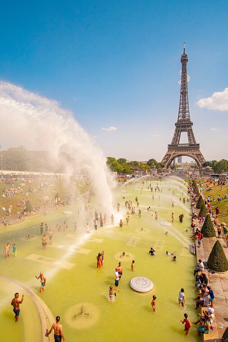 France, Paris, area listed as World Heritage by UNESCO, the Trocadero gardens in front of the Eiffel Tower, during the hot weather, bathing and water cannon\n