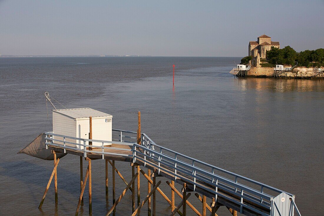 Frankreich, Charente Maritime, Mündung der Gironde, Talmont sur Gironde, beschriftet Les Plus Beaux Villages de France (Die schönsten Dörfer Frankreichs), Hütten auf Stelzen für Carrelet (Fischerhütte) Fischernetz, im Hintergrund St. Radegonde Kirche in Saintonge romanischer Stil des 12.