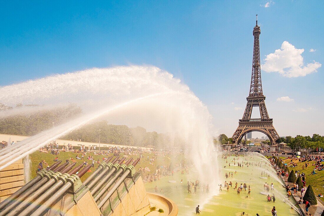 Frankreich, Paris, von der UNESCO zum Weltkulturerbe erklärtes Gebiet, die Trocadero-Gärten vor dem Eiffelturm, bei heißem Wetter, Baden und Wasserkanone