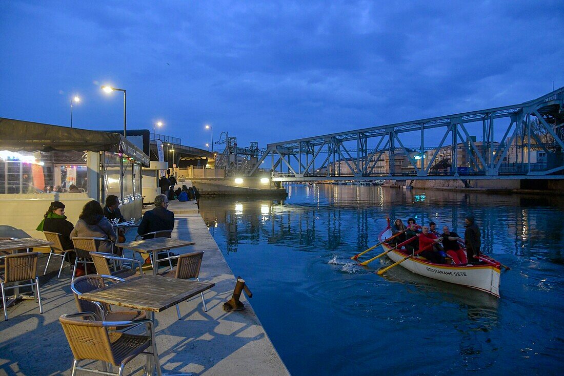 Frankreich, Herault, Sete, Pointe Courte, traditionelles Boot auf dem Kanal mit einem Deck im Hintergrund, gesehen bei Nacht