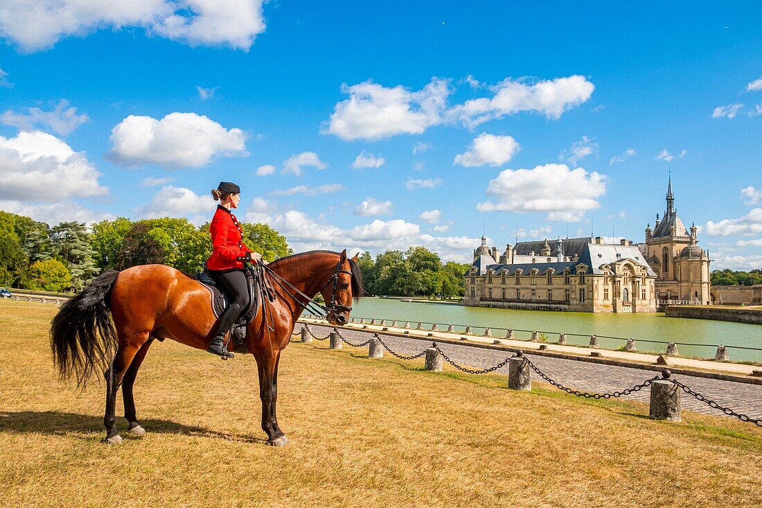 France, Oise, Chantilly, Chateau de Chantilly, the Grandes Ecuries (Great Stables), Clara rider of the Grandes Ecuries, runs his horse at the Spanish pace in front of the castle\n