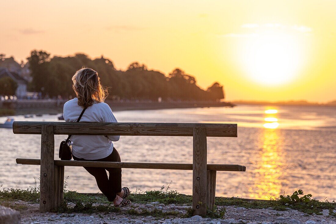 France, Somme, Somme Bay, Saint-Valery-sur-Somme, Young woman watching the sunset in Saint-Valery\n