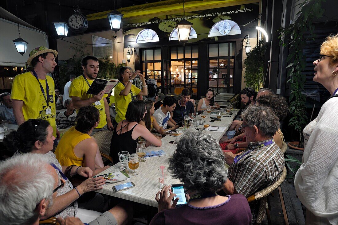 France, Vaucluse, Vaison la Romaine, Place Montfort, spontaneous choir in a bar at night during the Choralies in August\n