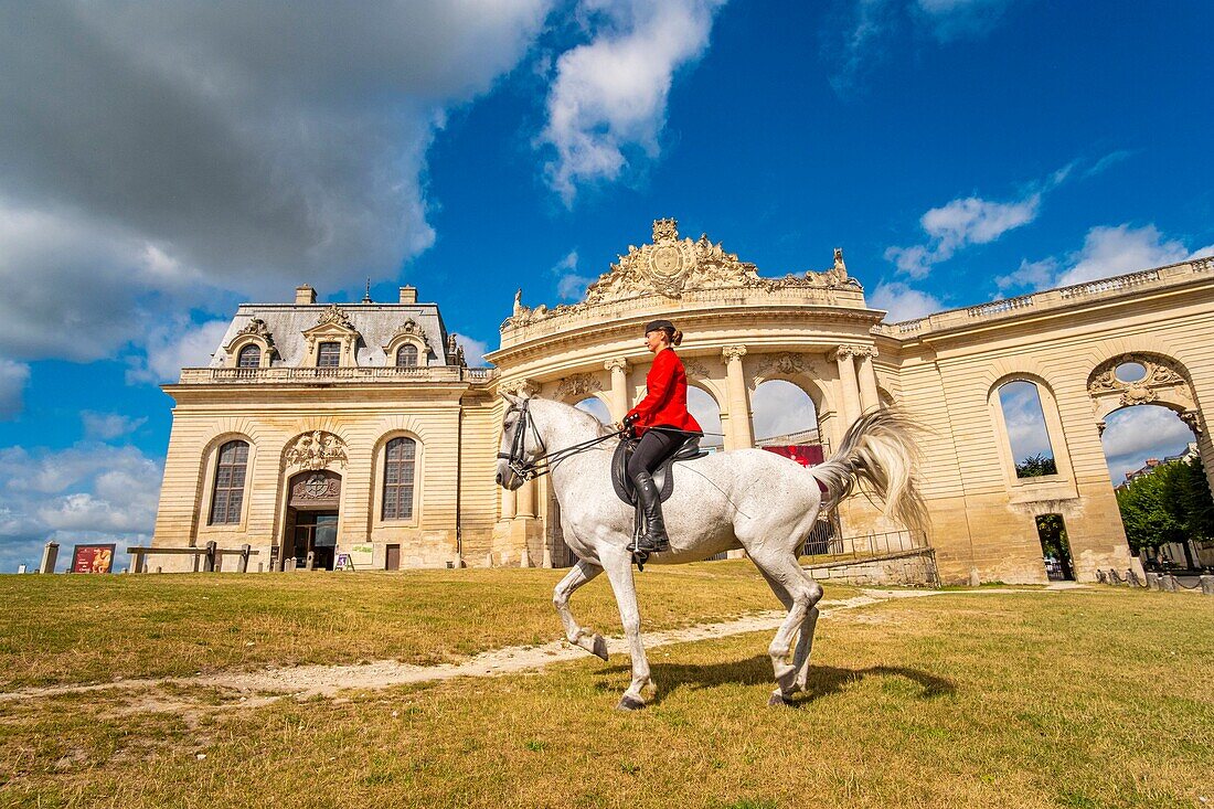 France, Oise, Chantilly, Chateau de Chantilly, the Grandes Ecuries (Great Stables), Clara rider of the Grandes Ecuries, runs his horse at the Spanish pace in front of the Grandes Ecuries (Great Stables)\n
