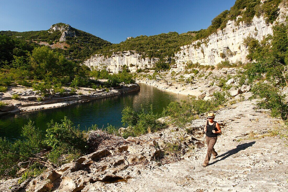 France, Ardeche, Ardeche Gorges National Natural Reserve, Sauze, Female hiker above Ardeche river, on the path of the Louby valley\n