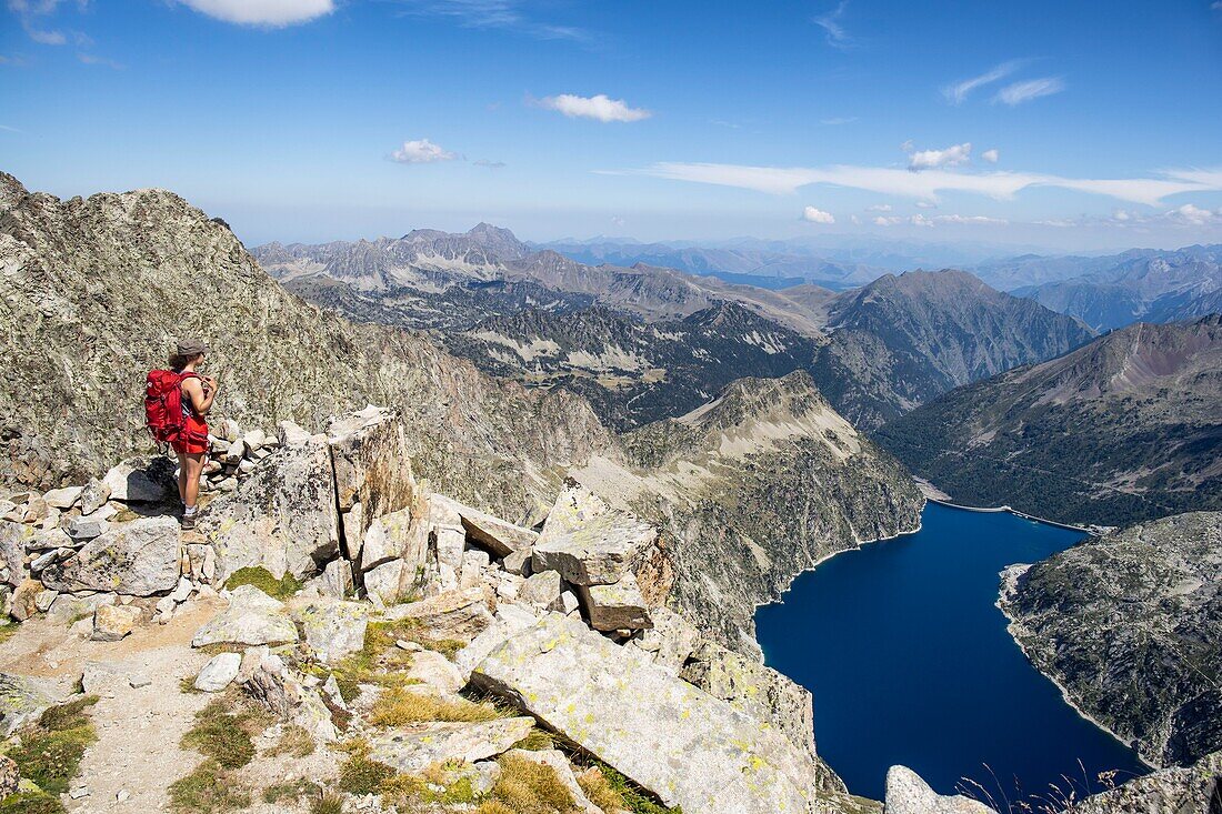 Frankreich, Hautes Pyrenees, Pyrenäen-Nationalpark, junger Wanderer auf dem Gipfel des Turon de Néouvielle (3035m), Blick nach unten auf den See Cap de Long (2161m)