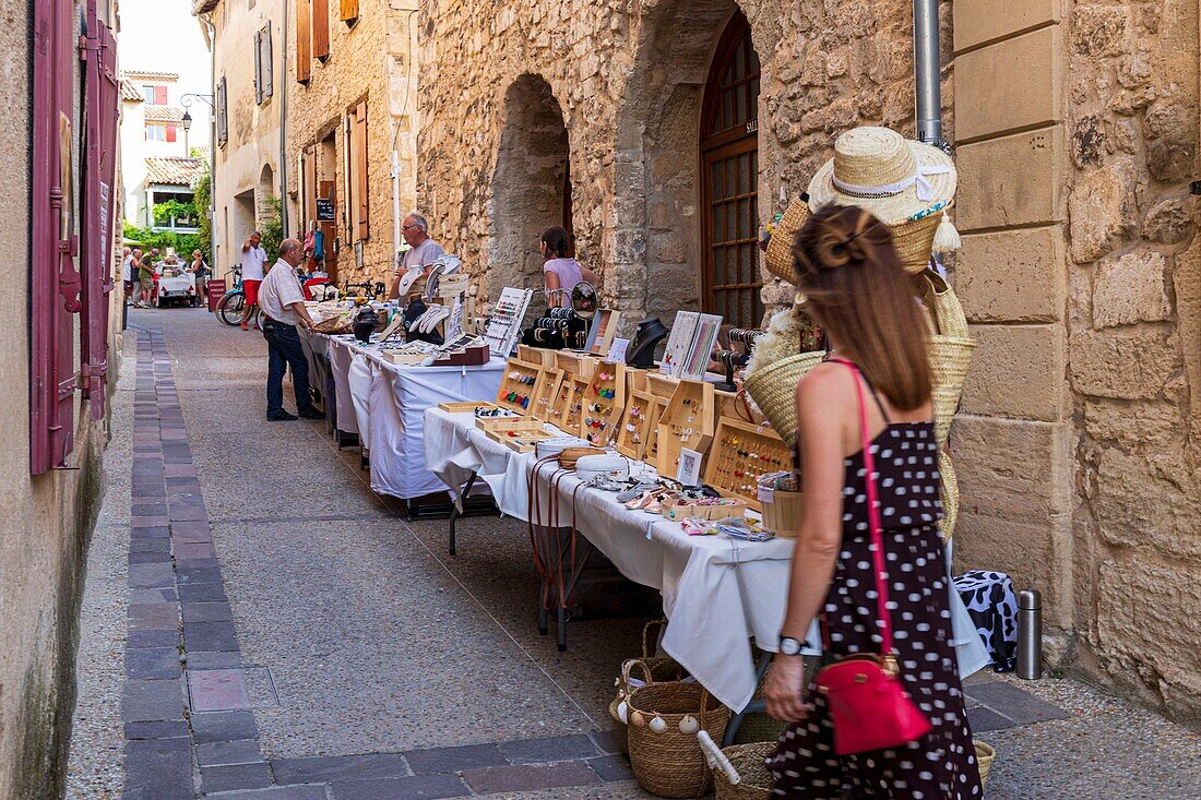 France, Vaucluse, Venasque, labeled the Most Beautiful Villages of France, stalls in a shaded alley\n