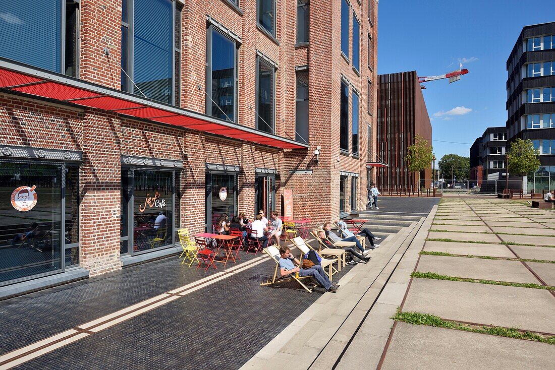 France, Nord, Lille, district of Bois Blancs, EuraTechnologies business park pole of excellence dedicated to the TIC of the Lille metropolis taking place in the Blan Lafont which is an old spinning mill built in 1900, some people lying in loungers\n