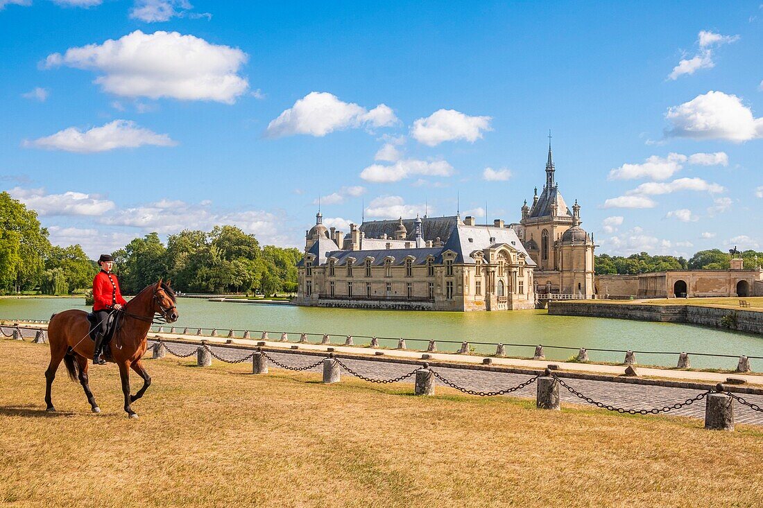 France, Oise, Chantilly, Chateau de Chantilly, the Grandes Ecuries (Great Stables), Clara rider of the Grandes Ecuries, runs his horse at the Spanish pace in front of the castle\n