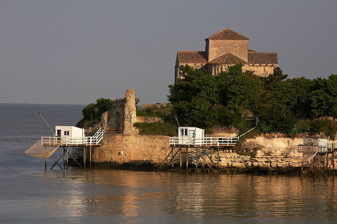 France, Charente Maritime, Gironde Estuary, Talmont sur Gironde, labelled Les Plus Beaux Villages de France (The Most Beautiful Villages of France), huts on stilts for Carrelet (fisherman's hut) fishing net and Sainte Radegonde church in Saintonge Romanesque style of the 12 th century\n