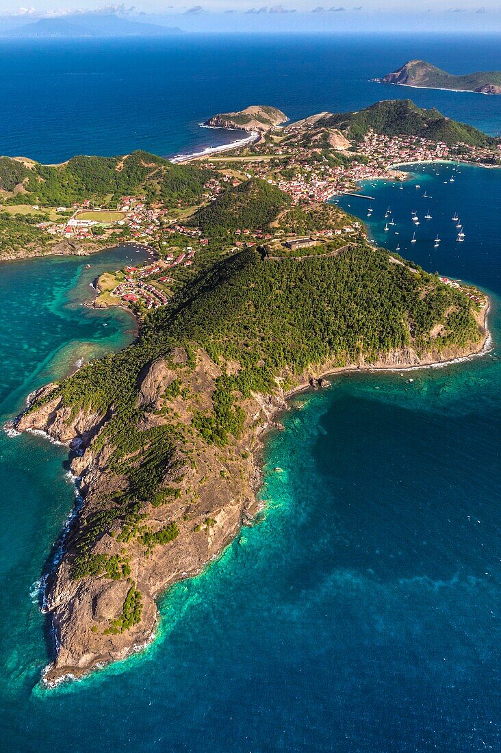 Guadeloupe, Les Saintes, Terre de Haut, the bay of the town of Terre de Haut, listed by UNESCO among the 10 most beautiful bays in the world, Dominica island in background (aerial view)\n