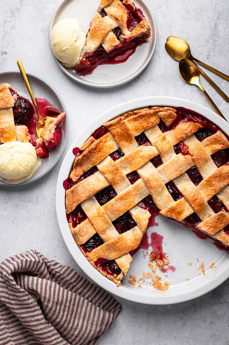 Pflaumenkuchen mit Mürbeteiggitter serviert mit Vanilleeis