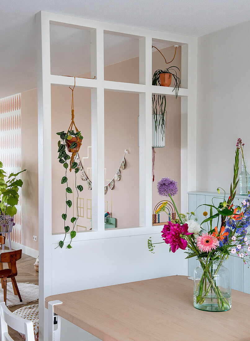 Open-plan dining area with room divider and hanging plants