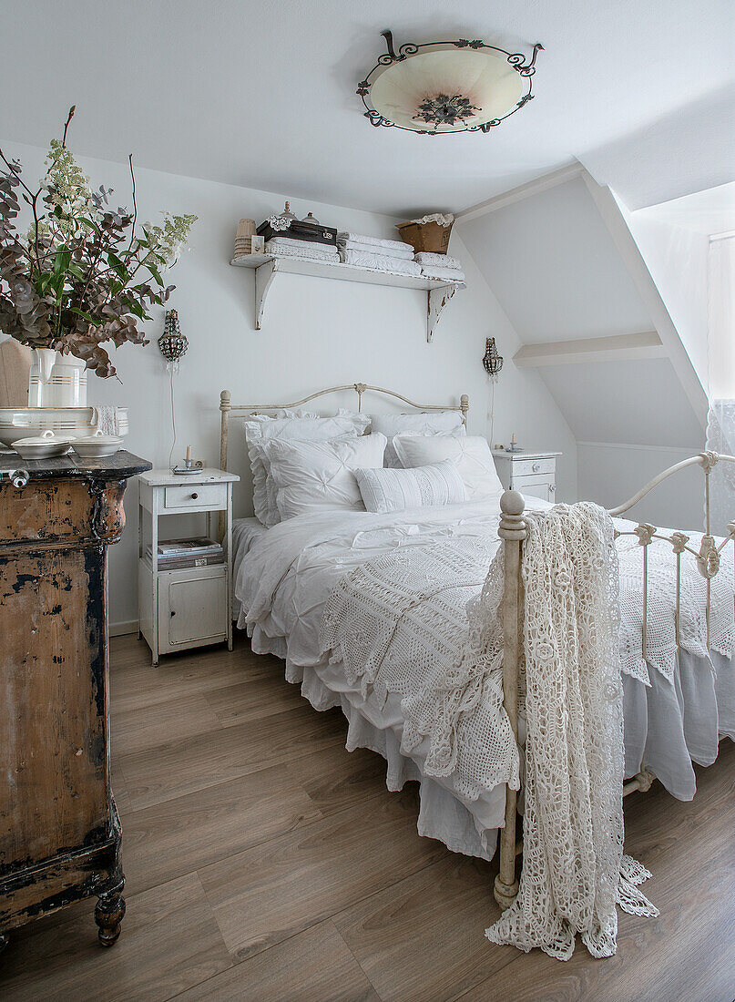 Metal bed with crocheted blankets in a country-style bedroom