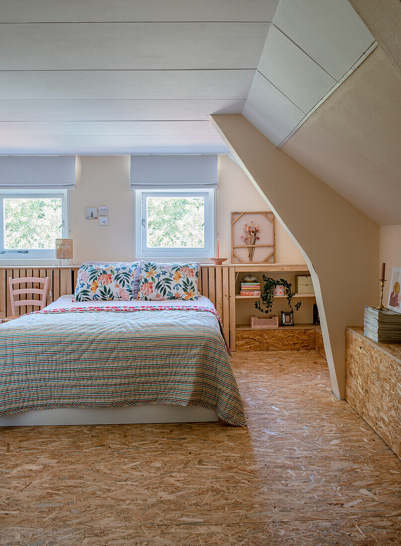 Cozy bedroom in the attic with coarse chipboard panels