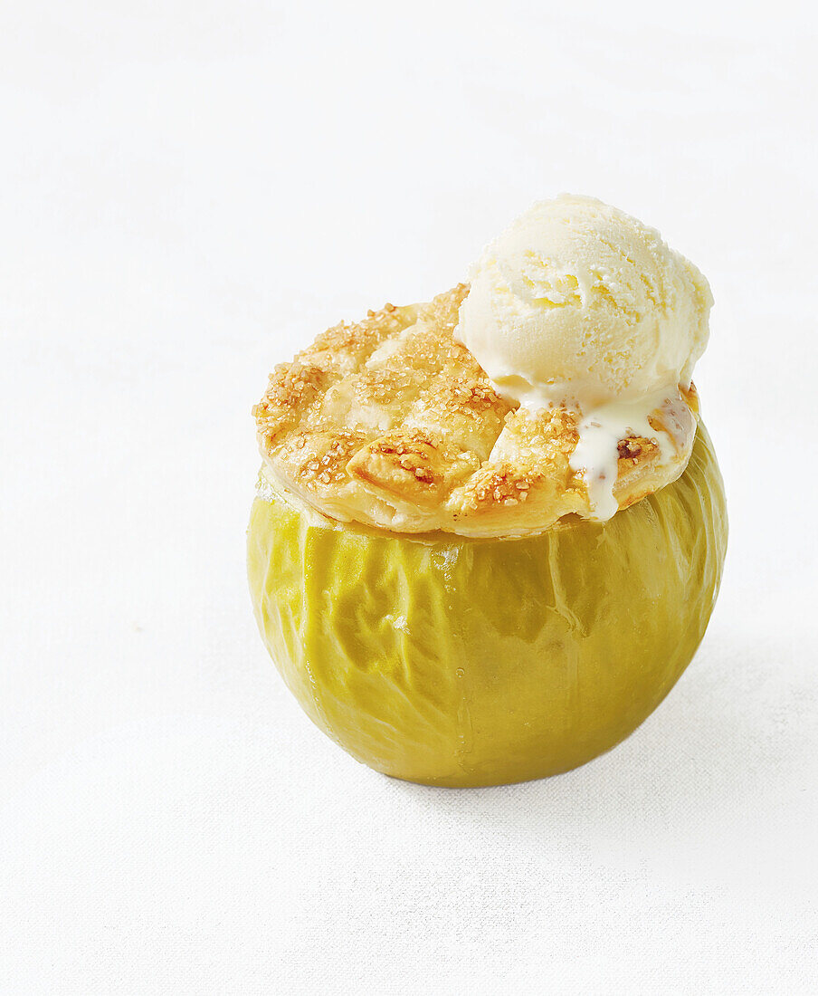 Stuffed baked apple with shortcrust pastry lid and vanilla ice cream