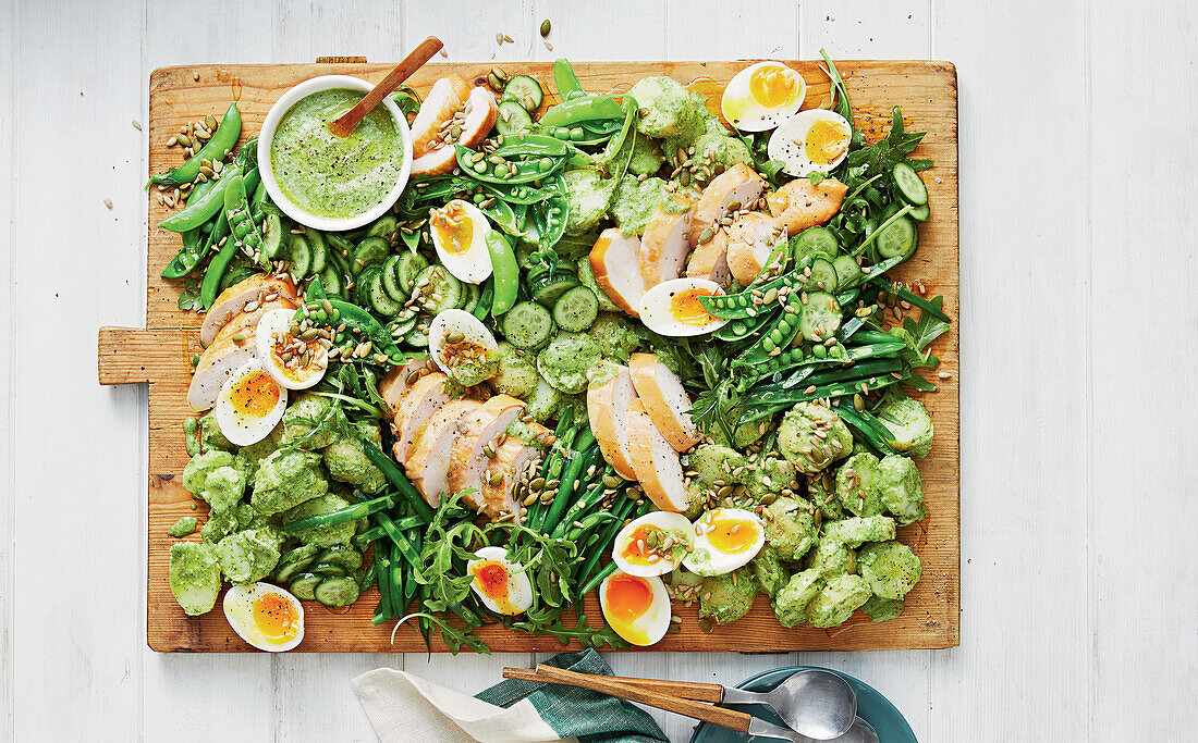 Smoked chicken breast with eggs, Brussels sprouts and peas on a wooden board