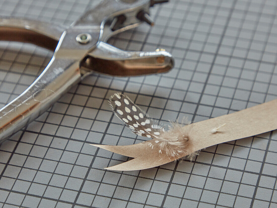 DIY project: Feathered paper decoration with hole punch pliers on a grid base