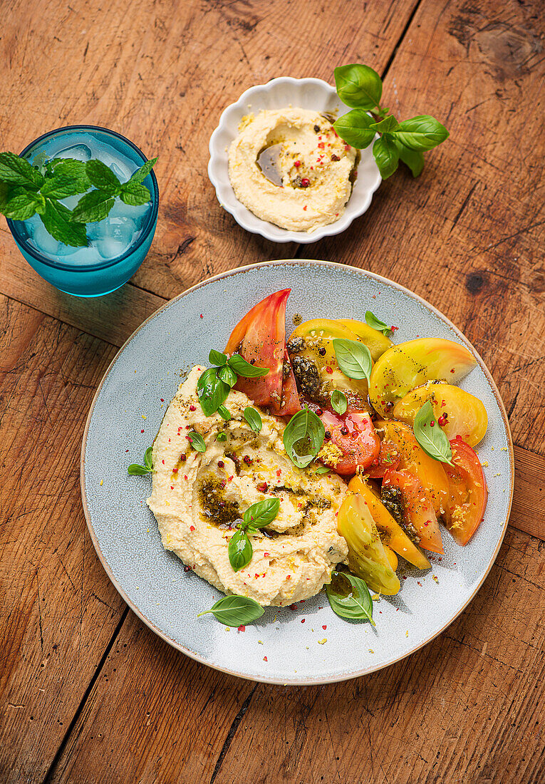 Colorful tomato salad with zaatar spiced oil and hummus