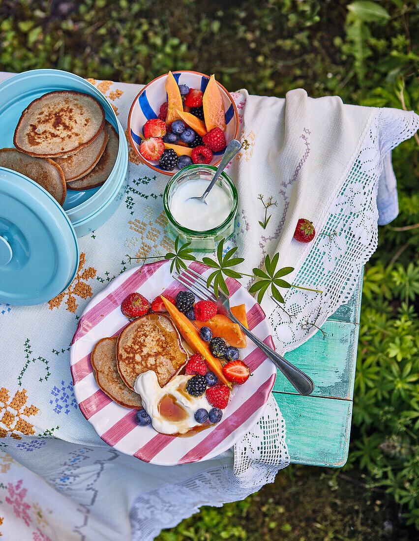 Banana and yogurt pancakes with papaya and berry salad