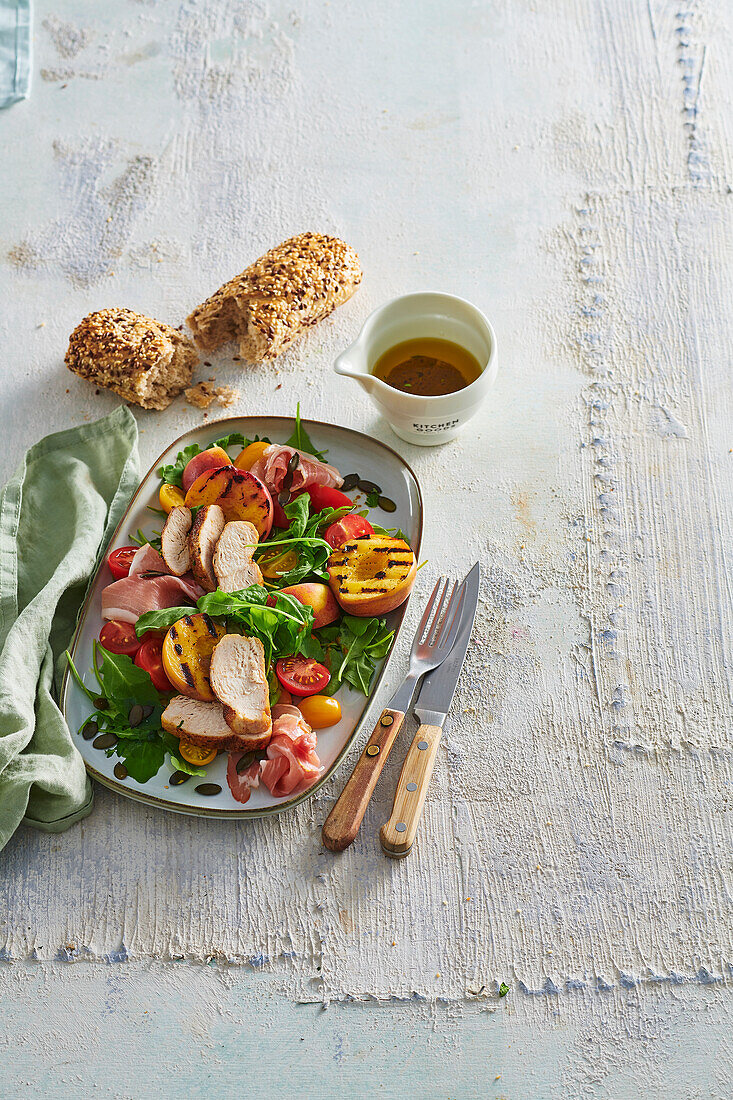 Chicken salad with grilled peaches, ham and rocket salad
