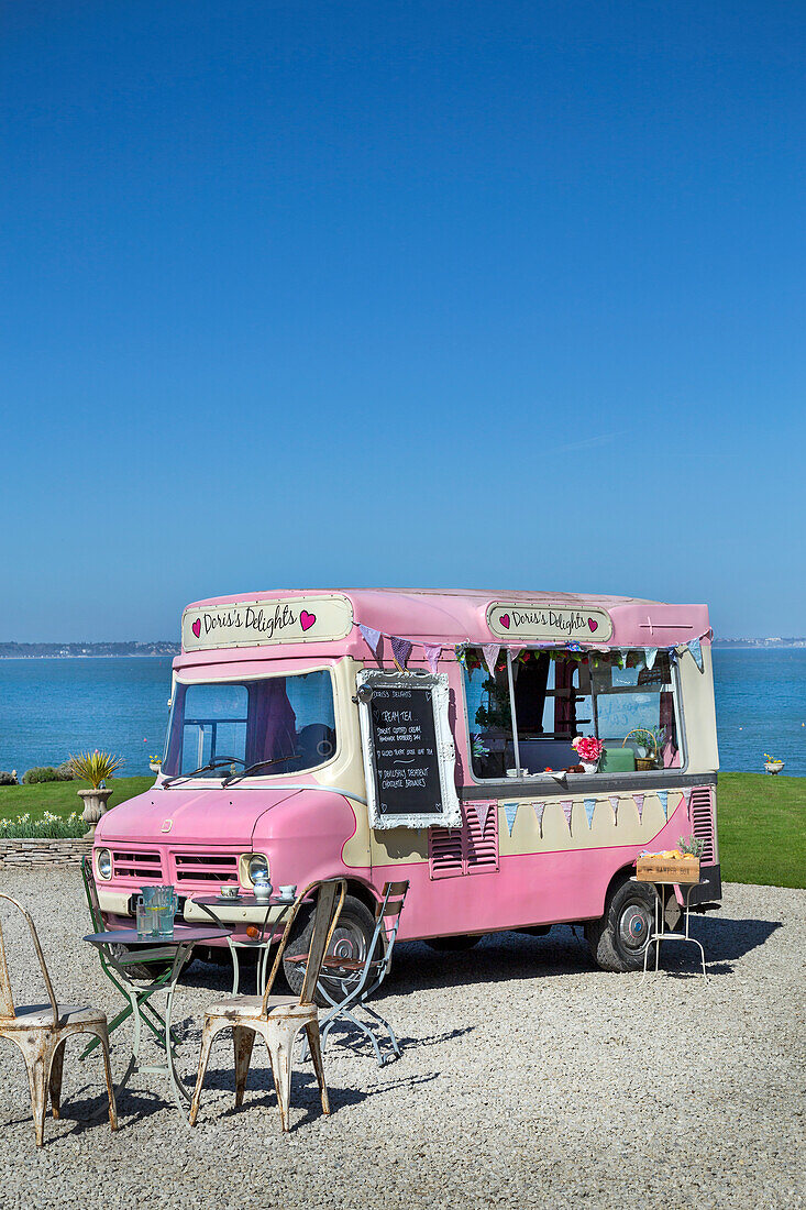 Vintage-style pink ice cream parlour with seating area by the sea