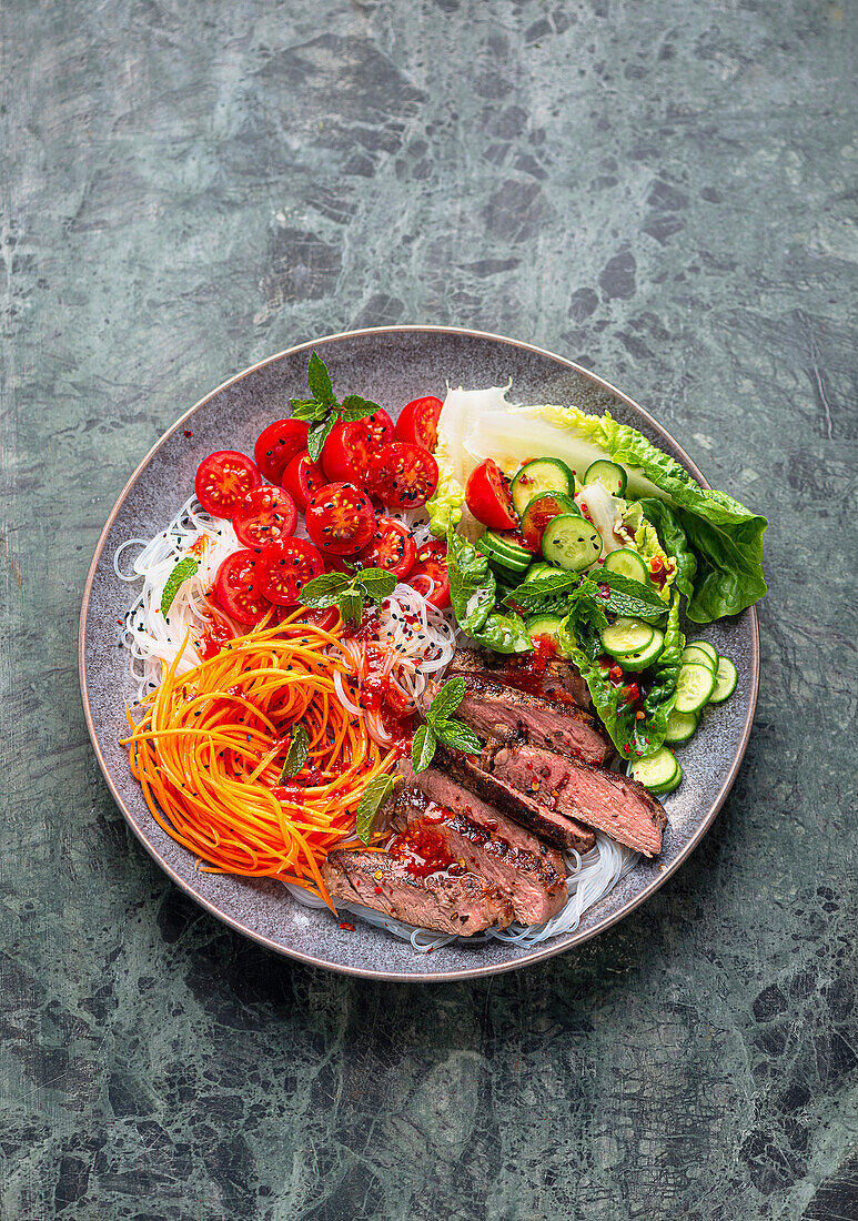 Rice noodle and vegetable bowl with steak