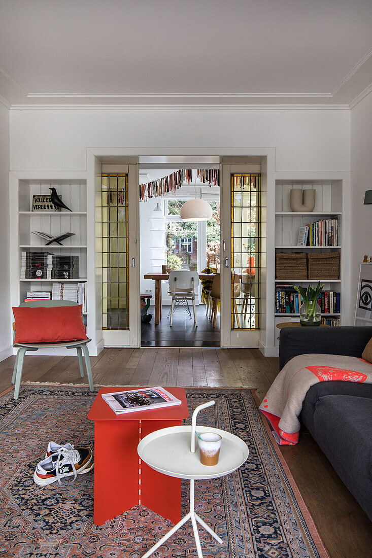 Living room with oriental rug, retro furniture and view through to the dining area