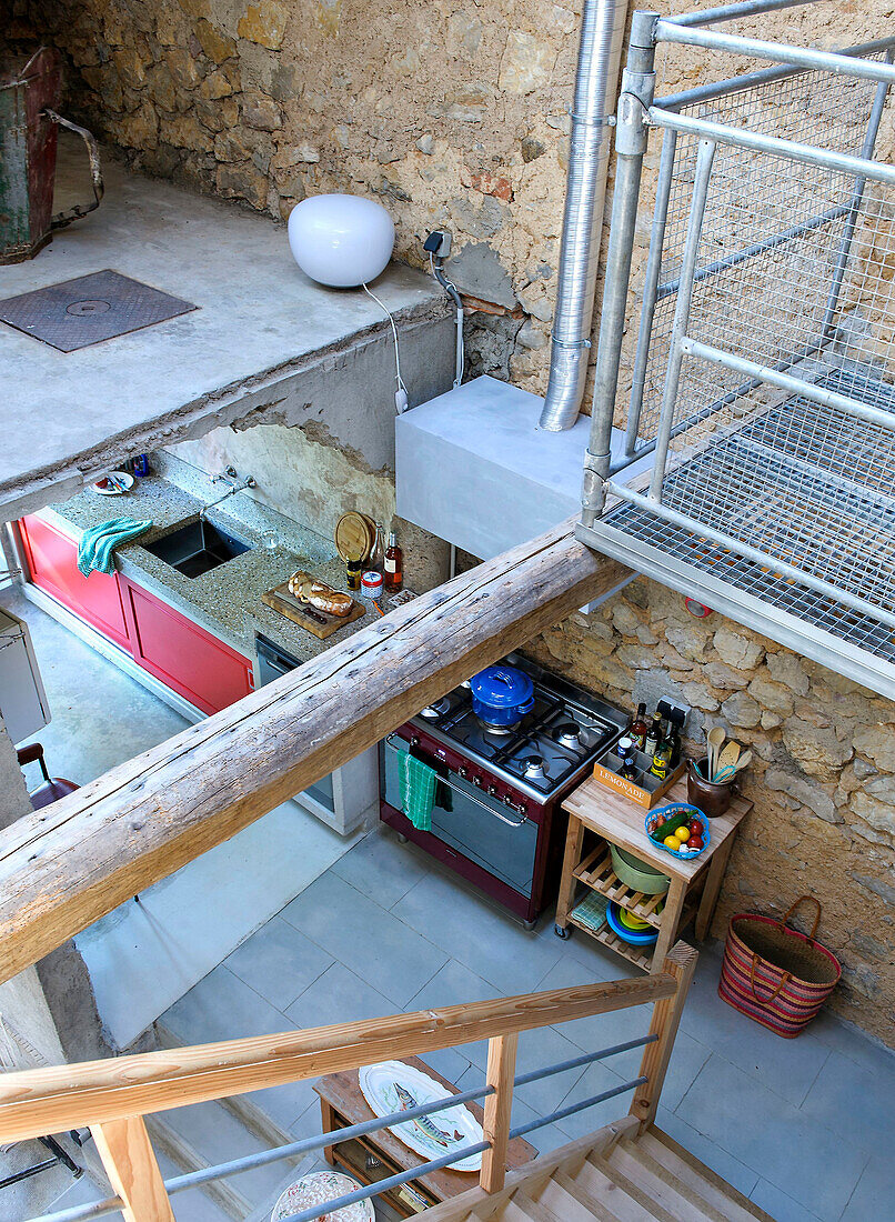 Blick von oben auf die Küche in einem Loft mit Natursteinwand