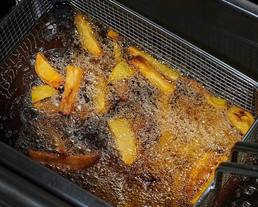 Potato wedges frying in oil
