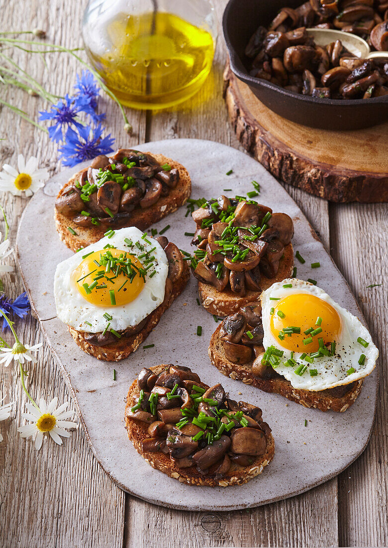 Bread topped with mushrooms and fried egg