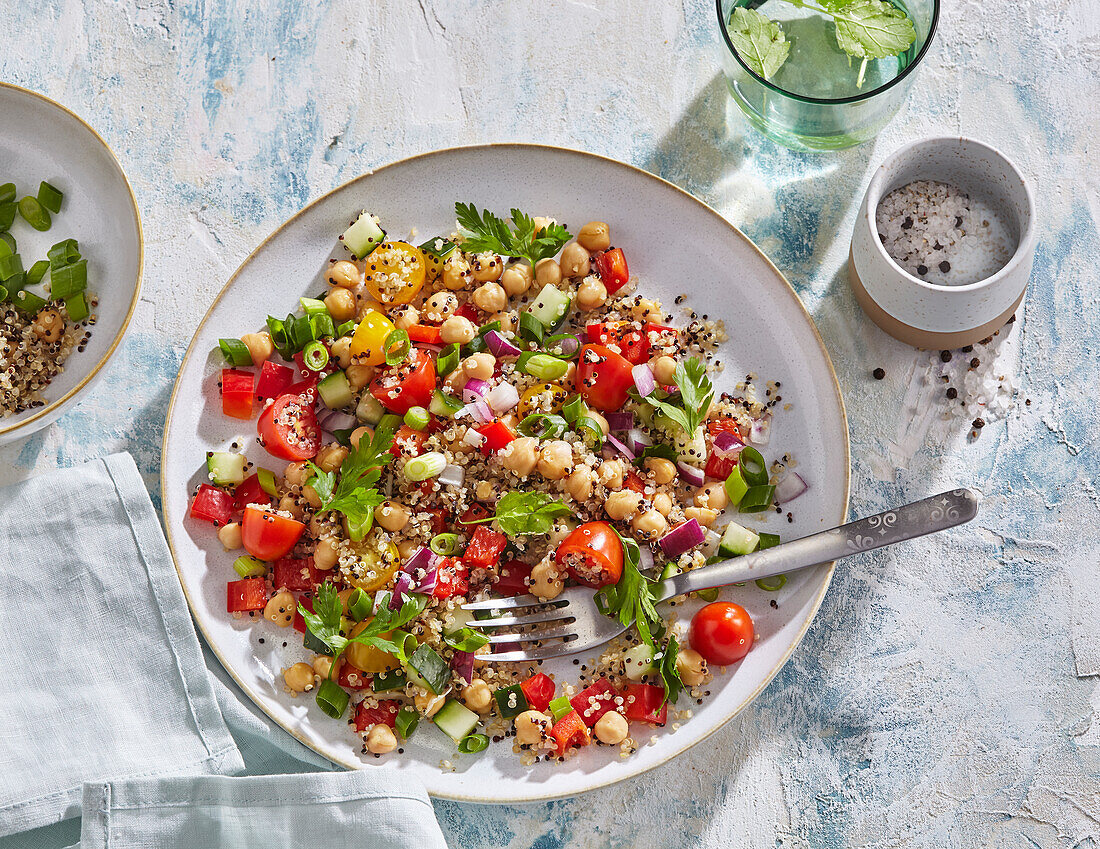 Fresh spring salad with quinoa, chickpeas, cucumber and tomatoes