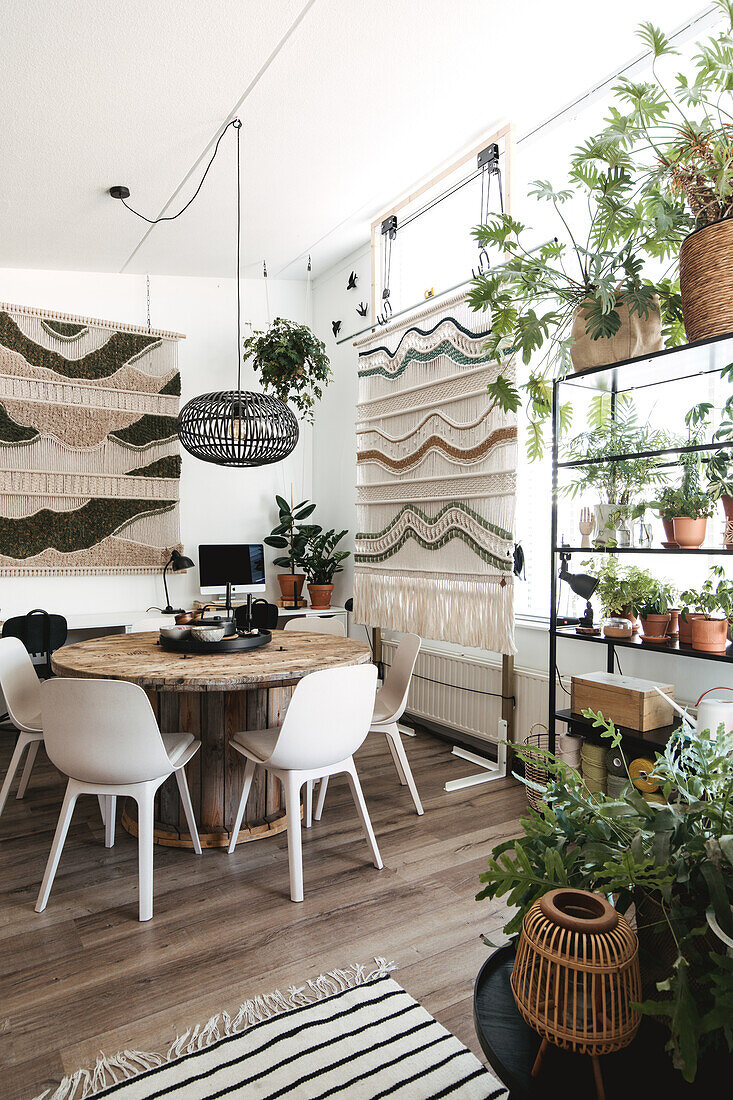 Dining area with lots of houseplants and boho-style tapestry