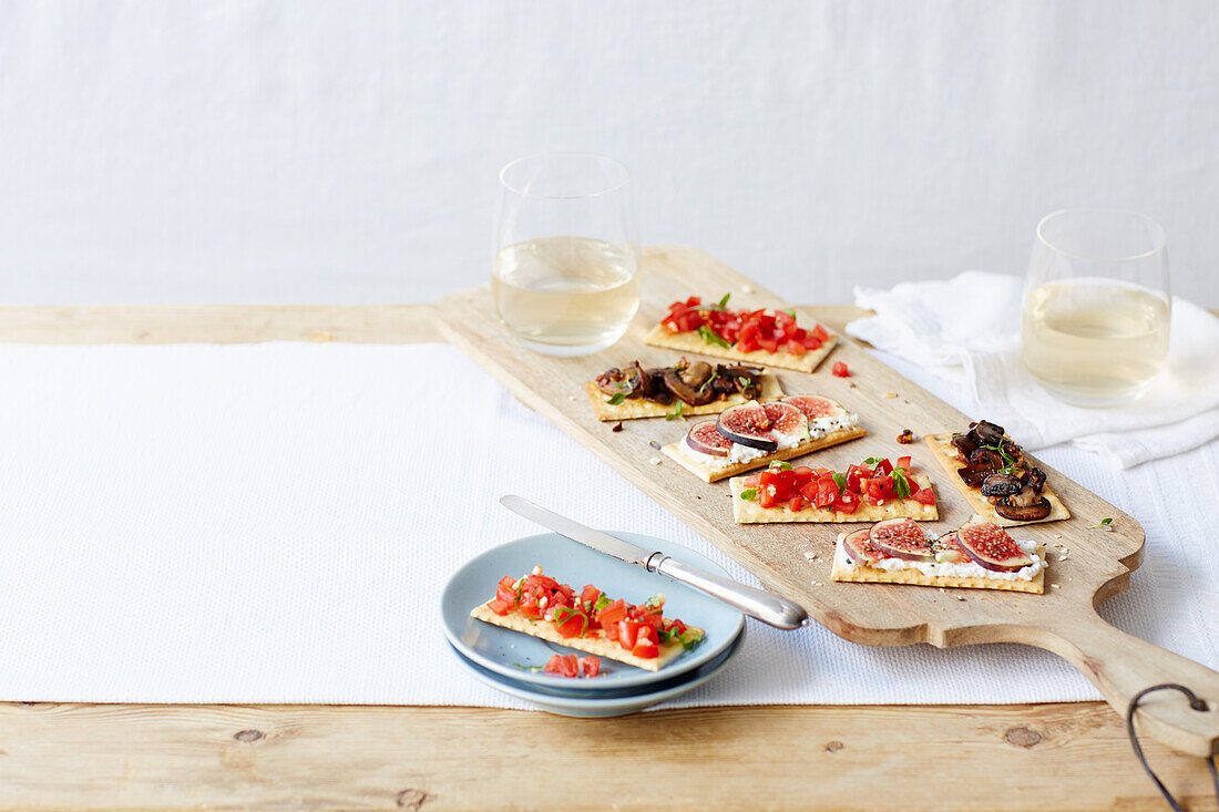 Crackers with tomatoes, figs, cream cheese and mushrooms