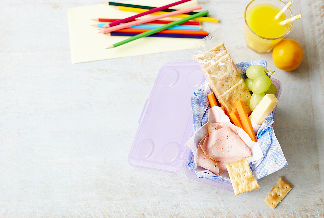 Snack box with crackers, carrots, ham and grapes