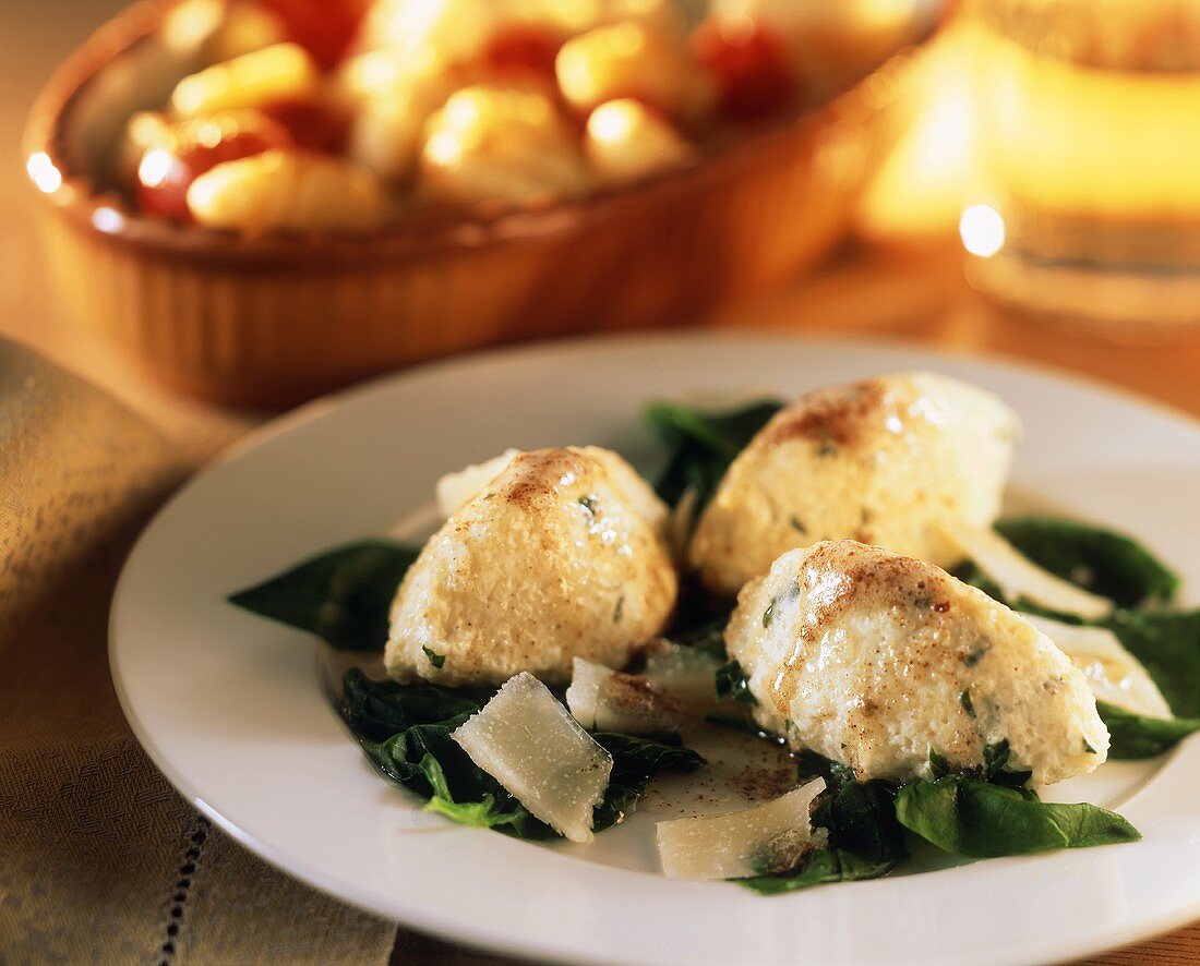 Spinach & quark dumplings on spinach with Parmesan curls