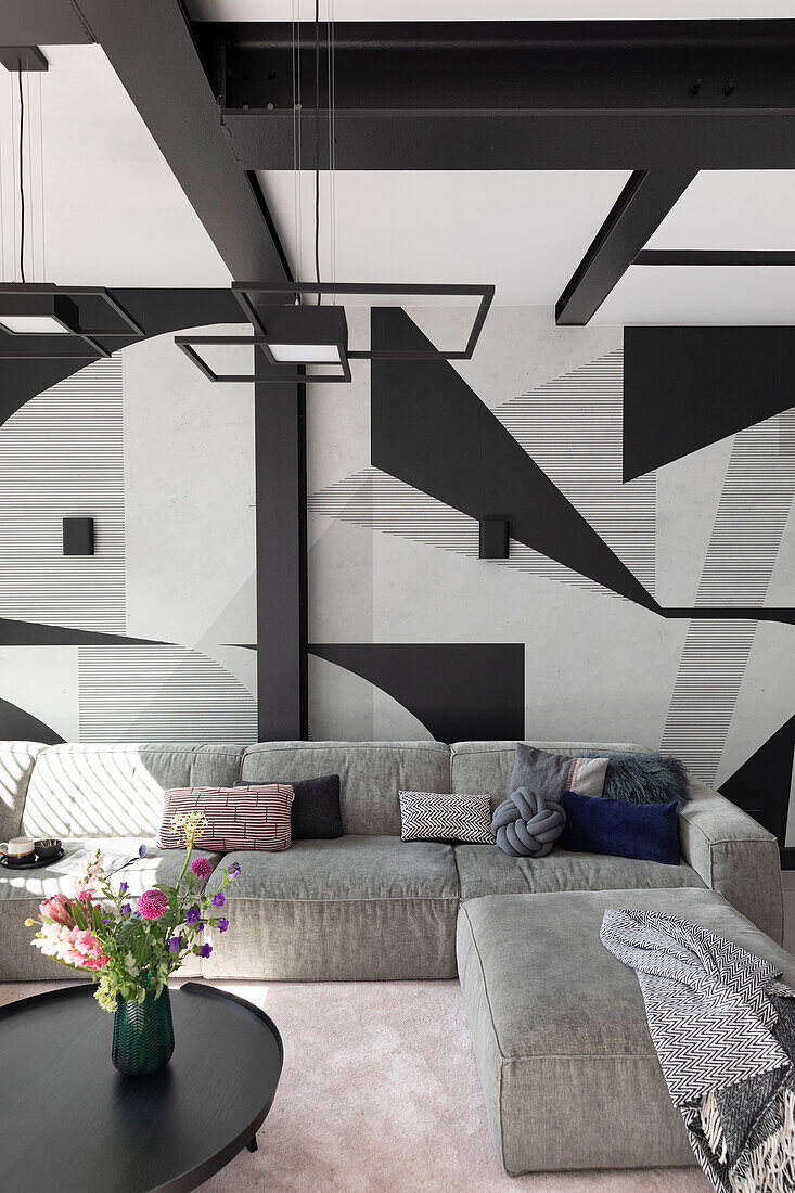 Modern living room with corner sofa and geometric wall art in black and white