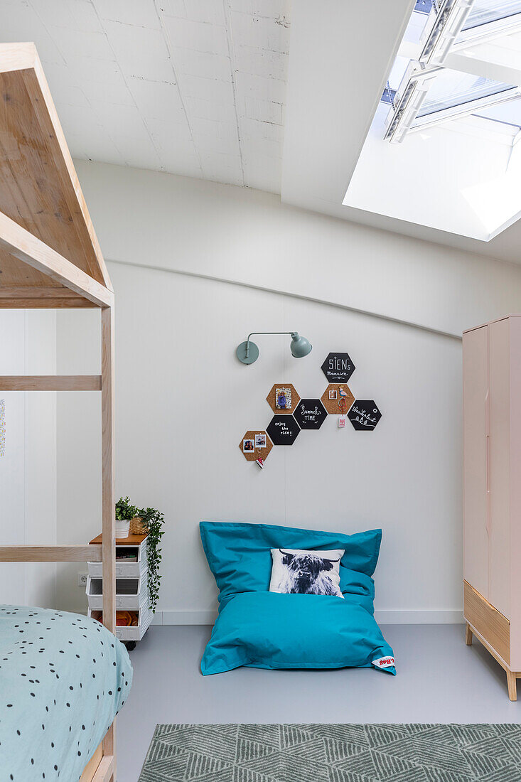 Teenage bedroom with skylight, bed and beanbag chair