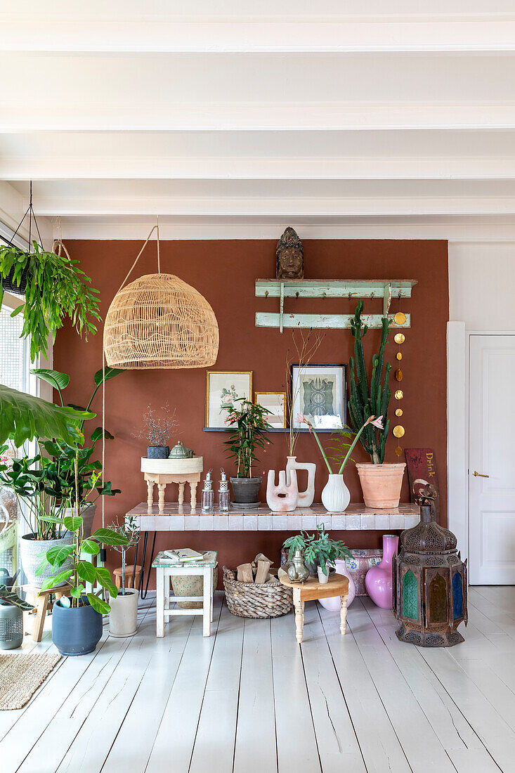 Urban jungle decor with houseplants in front of a terracotta-colored accent wall