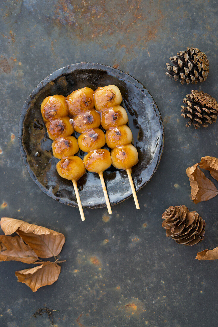 Grilled mochi on skewers with autumn decorations