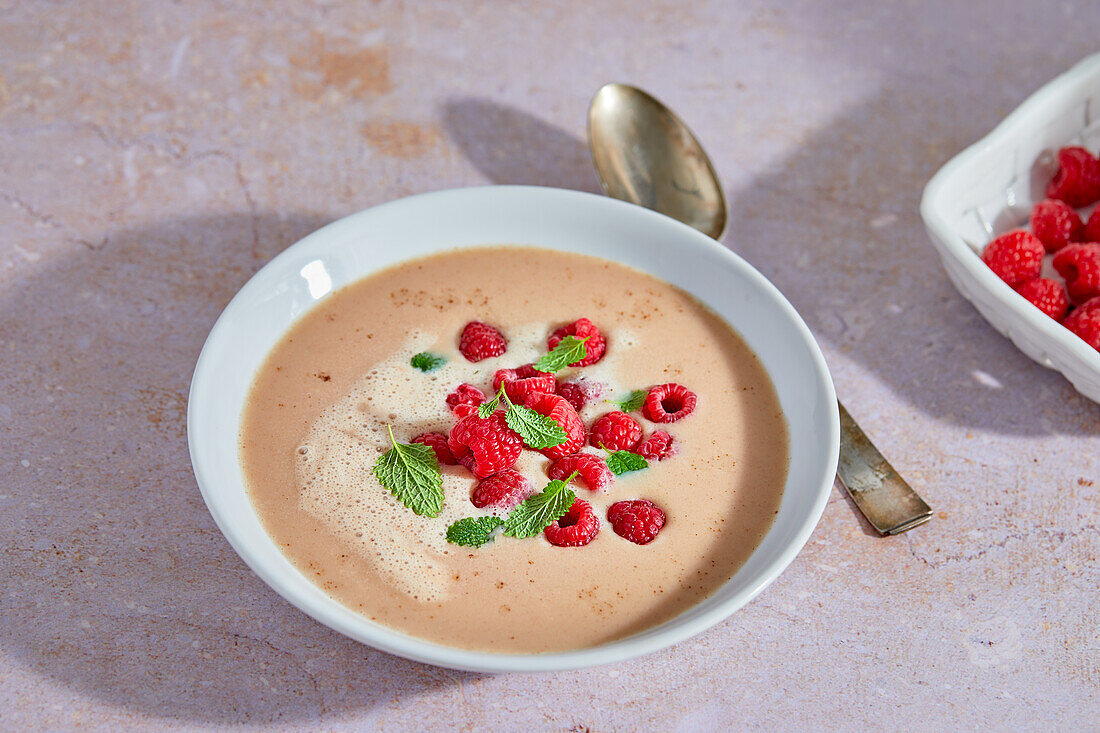 Warm almond cream soup with raspberries