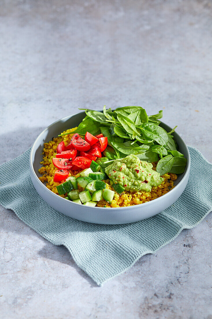 Cauliflower rice bowl with spinach and guacamole
