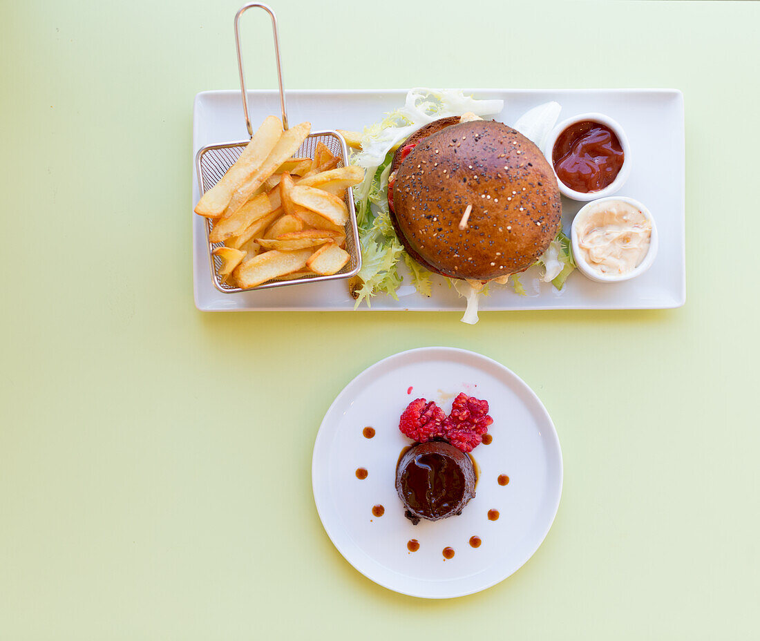 Hamburger with fries and cocoa cream with raspberries